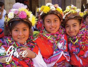 Three girls smiling wearing bright clothing